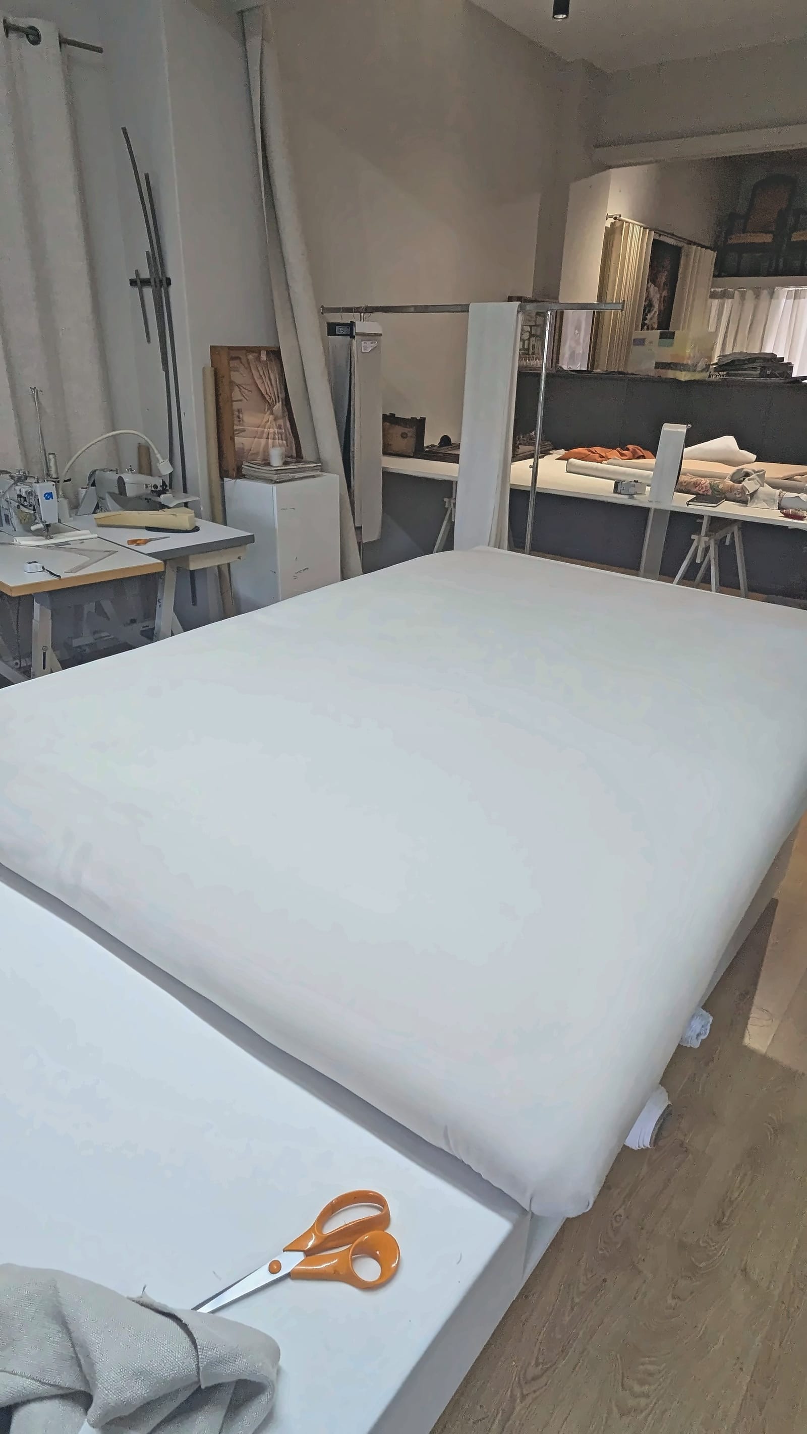A cabeceira de cama em linho vista de lado, com o rebordo estofado